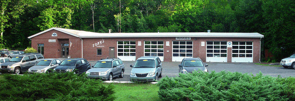 The front of Tony's Garage, with service bays and cars for sale in the parking lot.