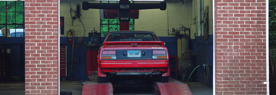 Inside a service bay at Tony's Garage, where a small red sports car is being serviced.